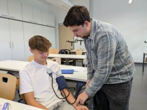 Einem Jugendlichen wird der Blutdruck gemessen.