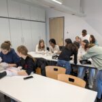 Schülerinnen sind beschäftigt damit, die Hühnerherzen aufzuschneiden.