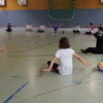 Schüler:innen machen Sitzvolleyball-Übungen