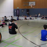 Schüler:innen machen Sitzvolleyball-Übungen