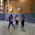 Schülerinnen titschen den Volleyball