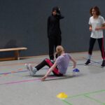 Schüler:innen machen Sitzvolleyball-Übungen