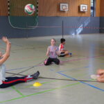 Schüler:innen spielen Sitzvolleyball