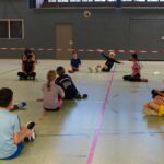 Schüler:innen spielen Sitzvolleyball