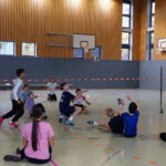 Schüler:innen spielen Sitzvolleyball