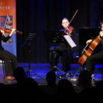 Drei Musiker spielen gemeinsam auf einer Bühne