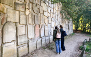 Zwei Mädchen gucken sich eine Steinwand an.