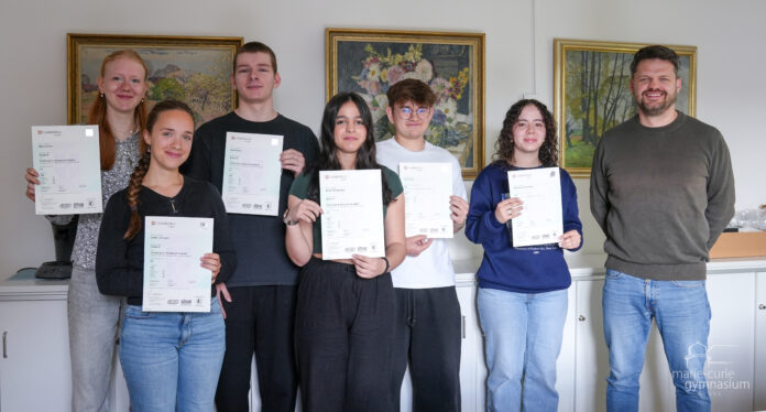 Schüler:innen erhalten ihre Urkunden vom Cambridge-Wettbewerb